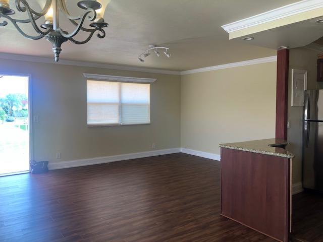 A kitchen features dark wood cabinets, granite countertops, stainless steel appliances, and a wine rack — 662 Saxony Trail N, Delray Beach FL 33446, DELRAY BEACH, FL