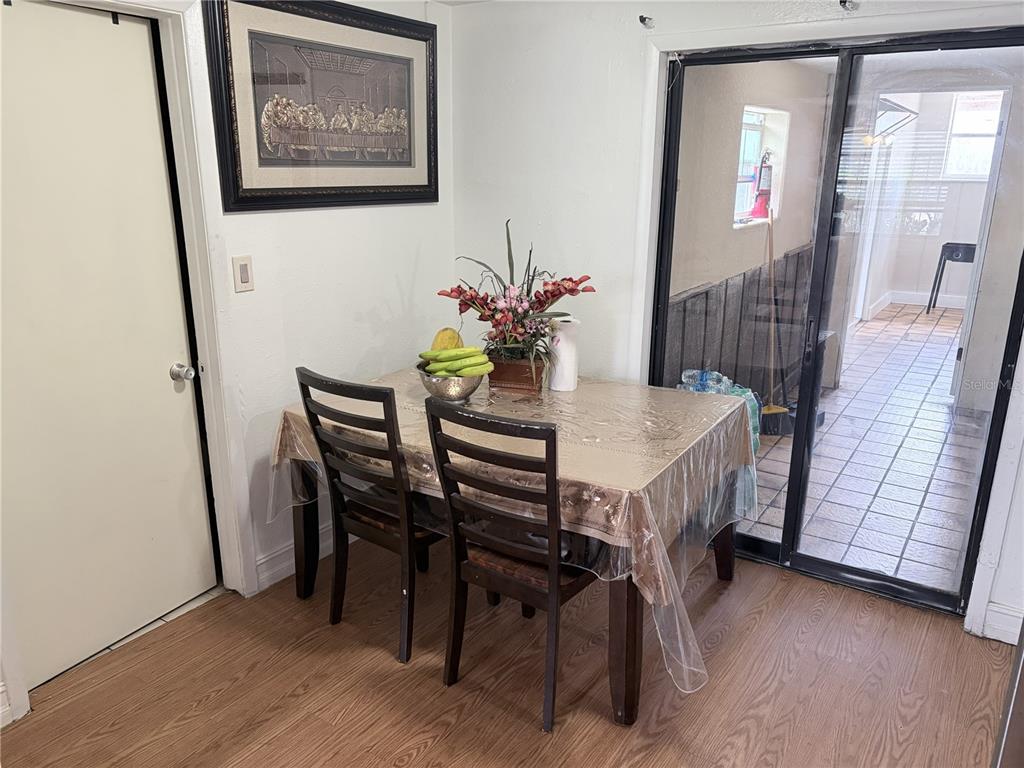 A dining area features a wooden table with two chairs, a framed picture, and sliding doors — 4802 E CURTIS STREET, TAMPA, FL