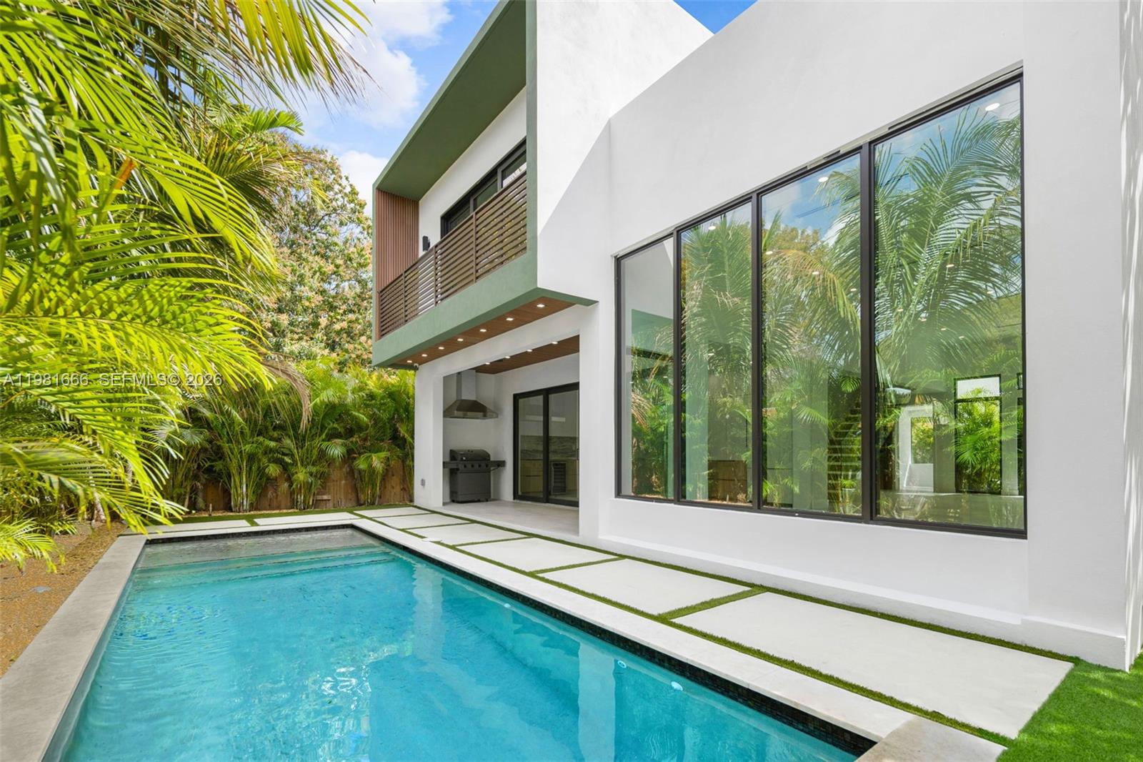 A modern two-story house with a swimming pool, patio, and large floor-to-ceiling windows — 569 NW 44th St, Miami FL 33127, MIAMI, FL