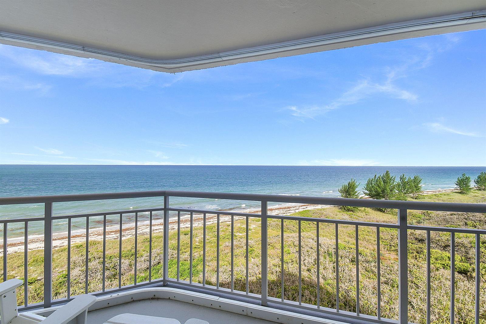 A balcony with a metal railing overlooks a sandy beach and the ocean — 3870 N Highway A1a # 805, Fort Pierce FL 34949, FORT PIERCE, FL
