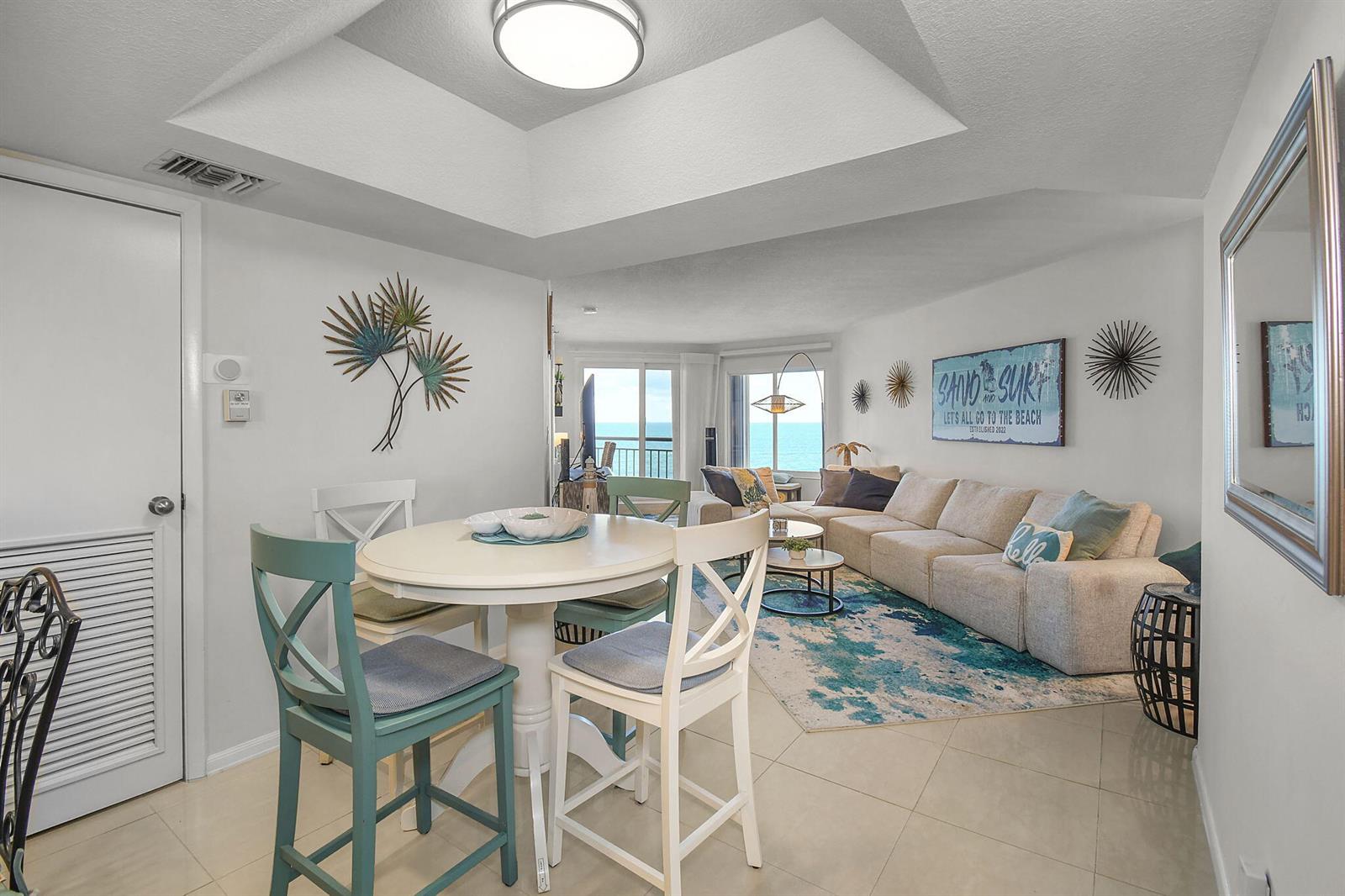 A dining area with a round table opens into a living room overlooking the ocean — 3870 N Highway A1a # 805, Fort Pierce FL 34949, FORT PIERCE, FL