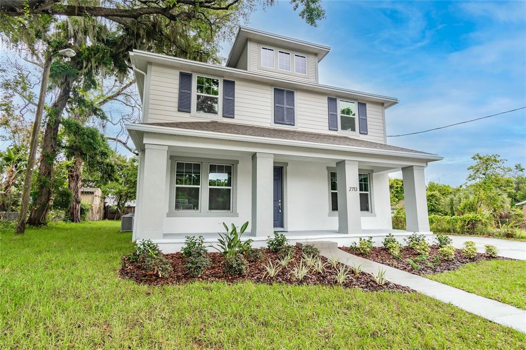 A vacant residential lot is enclosed by a black construction fence between two existing houses — 114 W PLYMOUTH STREET, TAMPA, FL