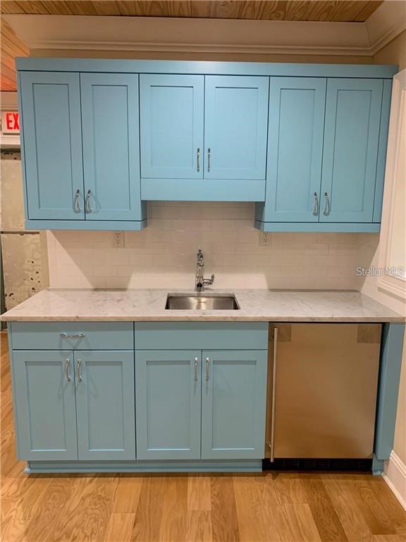 A wet bar features light blue cabinets, a marble countertop, and a stainless steel undercounter refrigerator — 2515 E SOUTH STREET, ORLANDO, FL