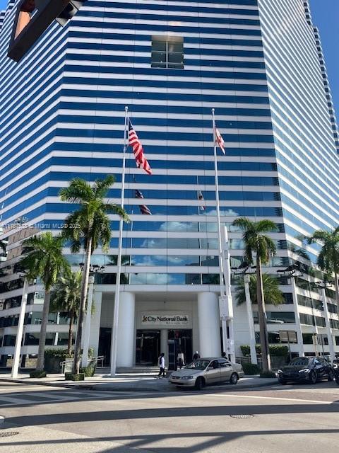 A low-angle view of a modern glass skyscraper with City National Bank signage at the entrance — 100 SE 2 ST # 2000, Miami FL 33131, MIAMI, FL