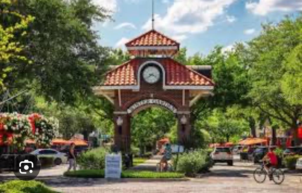 A brick clock tower archway stands over a pathway in a tree-lined outdoor area — 47 OAK STREET, WINTER GARDEN, FL