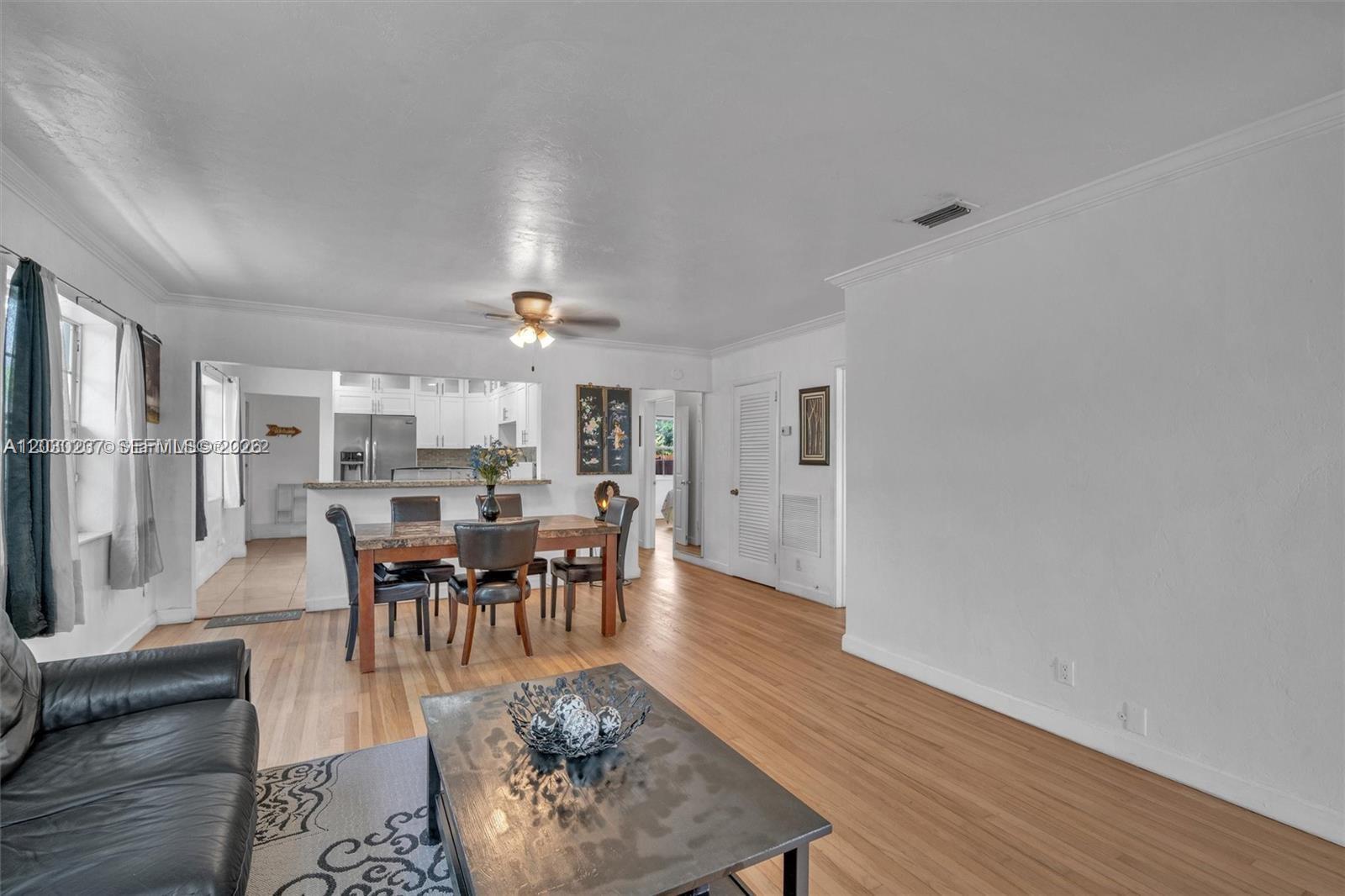 A living and dining area features hardwood floors, a ceiling fan, and an open kitchen — 1635 Hollywood Blvd # A, Hollywood FL 33020, HOLLYWOOD, FL