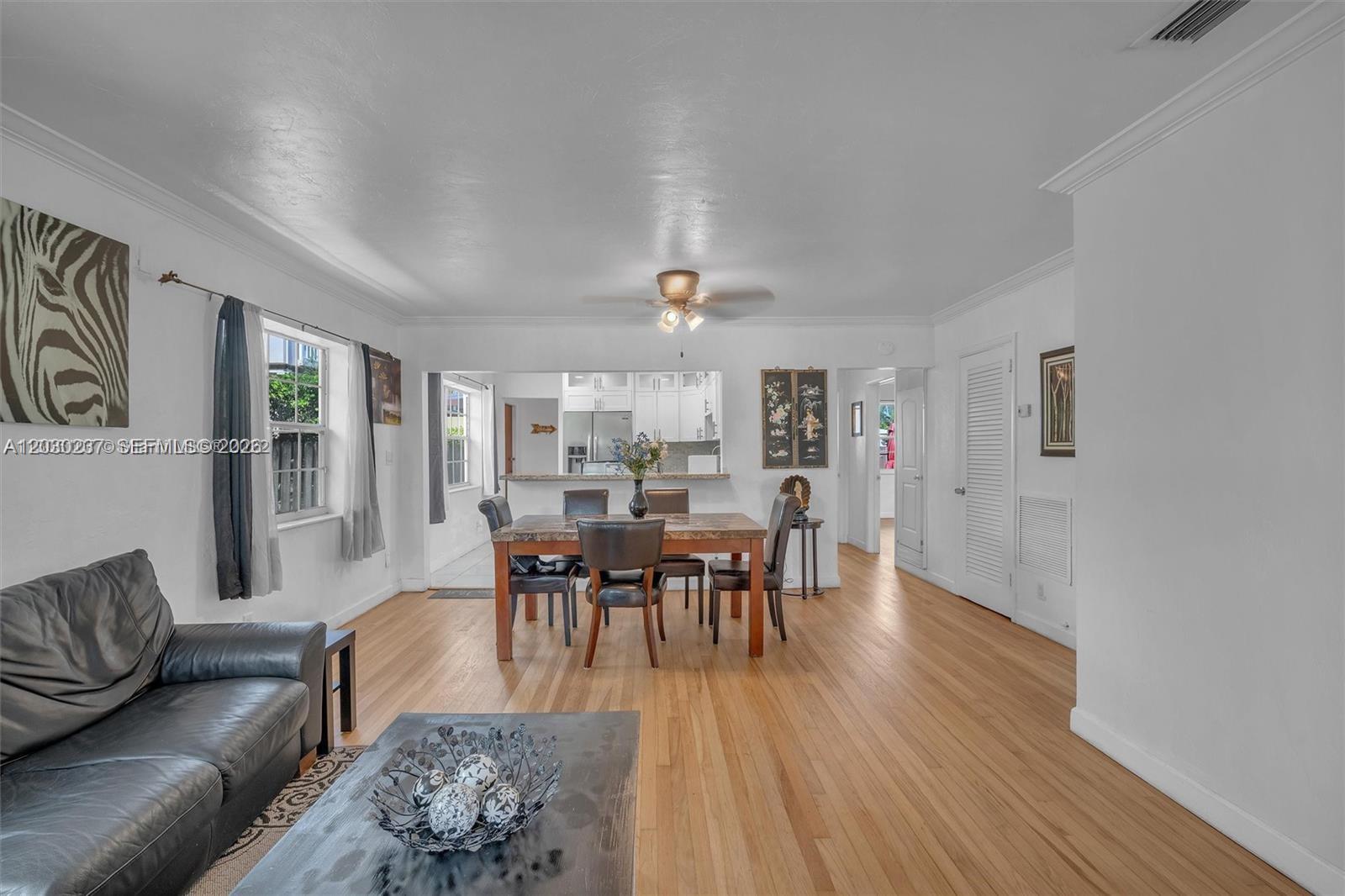 A living and dining area features hardwood floors, white walls, and a kitchen pass-through — 1635 Hollywood Blvd # A, Hollywood FL 33020, HOLLYWOOD, FL