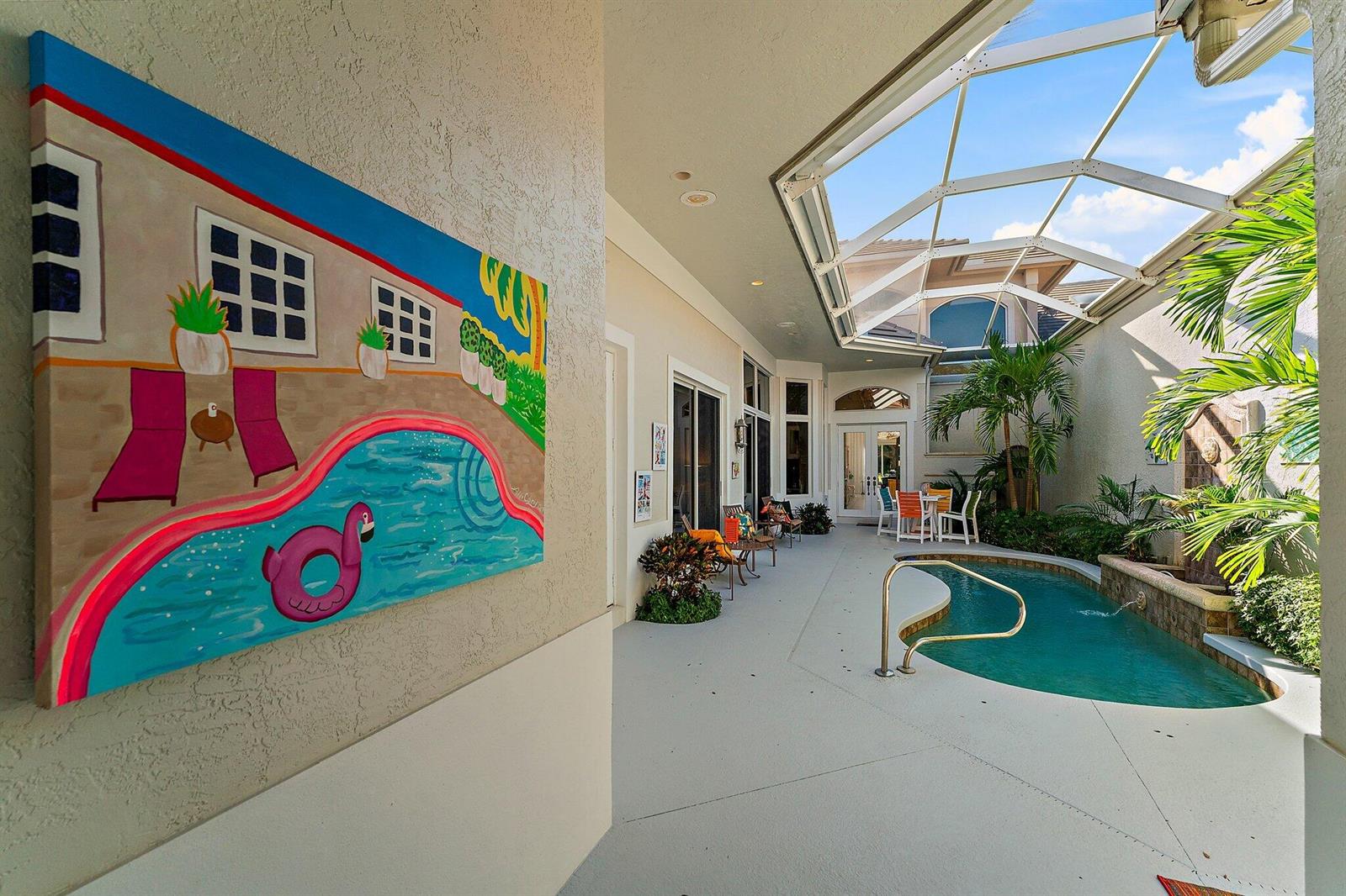 A covered patio features a small swimming pool, a screen enclosure, and a wall painting — 12020 SE Birkdale Run, Jupiter FL 33469, JUPITER, FL