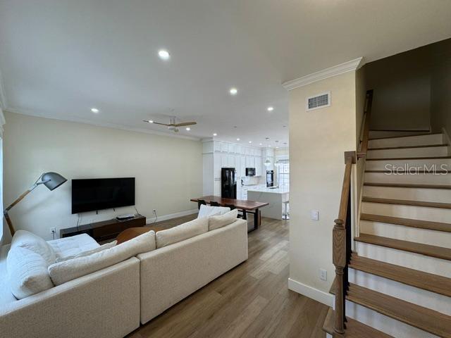 A living room with a sectional sofa, television, and stairs leading to an upper level — 537 CAMPUS STREET, CELEBRATION, FL