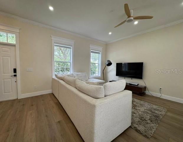 A living room features light wood flooring, a white sectional sofa, and a wall-mounted television — 537 CAMPUS STREET, CELEBRATION, FL
