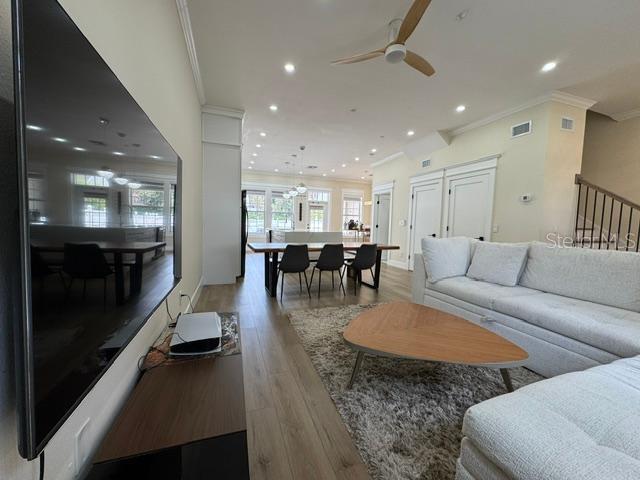 A modern living room features a large television, a sectional sofa, and a dining area — 537 CAMPUS STREET, CELEBRATION, FL