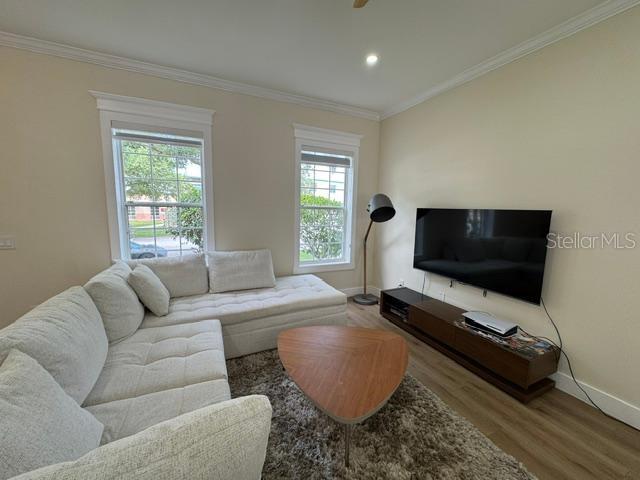 A living room features a white sectional sofa, a triangular coffee table, and a wall-mounted television — 537 CAMPUS STREET, CELEBRATION, FL