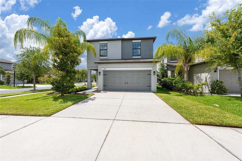 A living room features a gray sectional sofa, a black media console, and a ceiling fan — 7423 CLARY SAGE AVENUE, TAMPA, FL