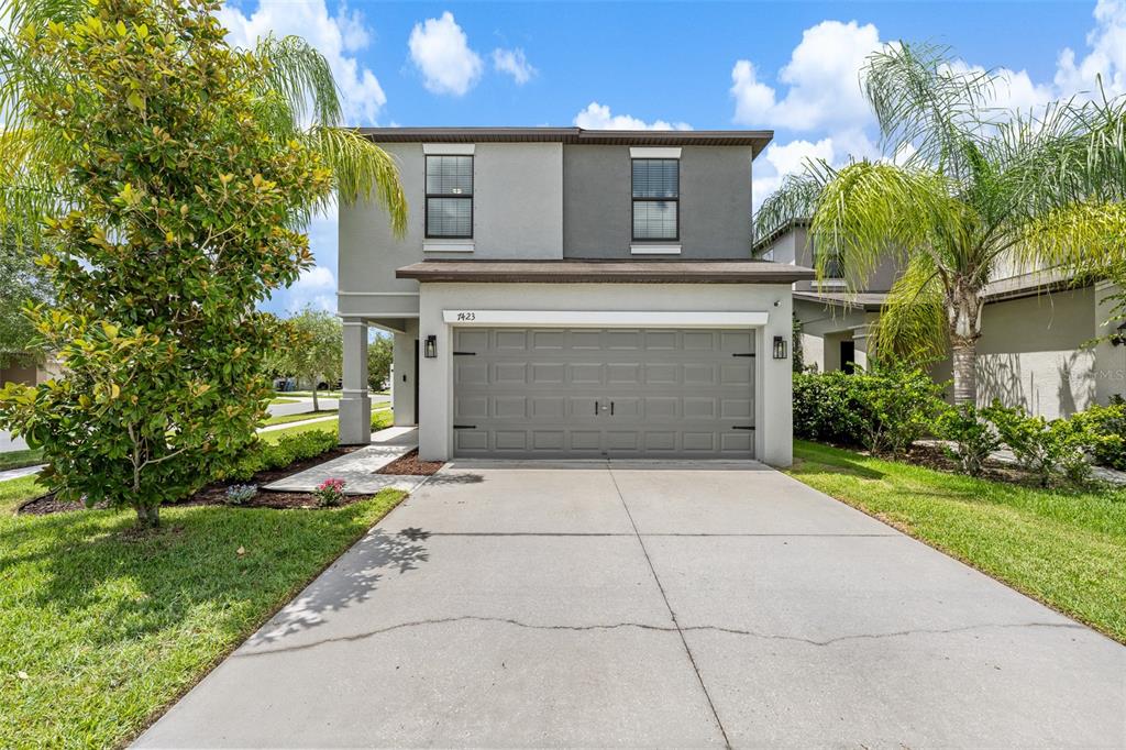 A dining area features a round wooden table, chairs, a chandelier, and a sliding glass door — 7423 CLARY SAGE AVENUE, TAMPA, FL
