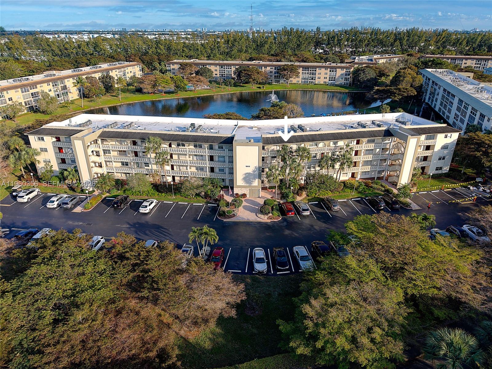An aerial view shows a rectangular swimming pool surrounded by lounge chairs and patio tables — 1803 Eleuthera Pt # G4, Coconut Creek FL 33066, COCONUT CREEK, FL