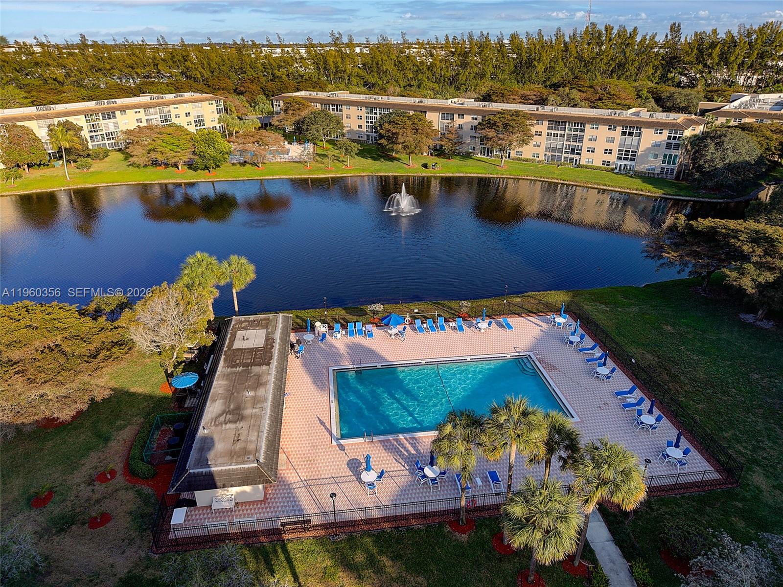 An aerial view shows a rectangular swimming pool surrounded by lounge chairs and patio tables — 1803 Eleuthera Pt # G4, Coconut Creek FL 33066, COCONUT CREEK, FL