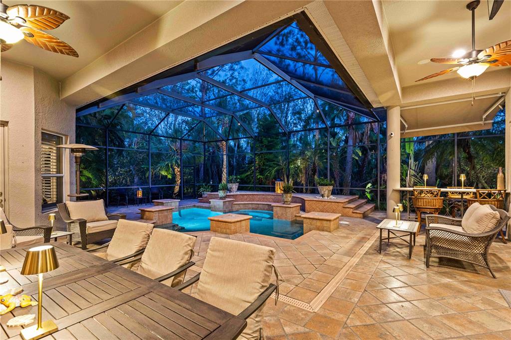 A covered patio features a swimming pool, outdoor seating, and a screened-in enclosure — 10006 DISCOVERY TERRACE, BRADENTON, FL