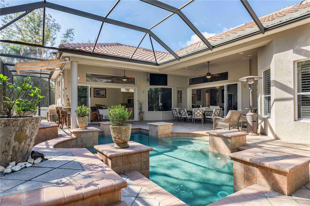 A screened-in patio features a swimming pool, tiled deck, and outdoor seating area — 10006 DISCOVERY TERRACE, BRADENTON, FL