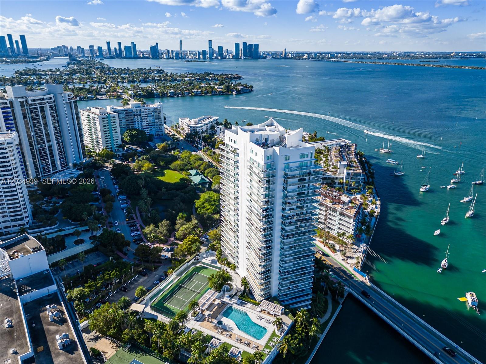 An aerial view shows a high-rise residential building with a pool and tennis court — 10 Venetian Way, Miami Beach FL 33139, MIAMI BEACH, FL