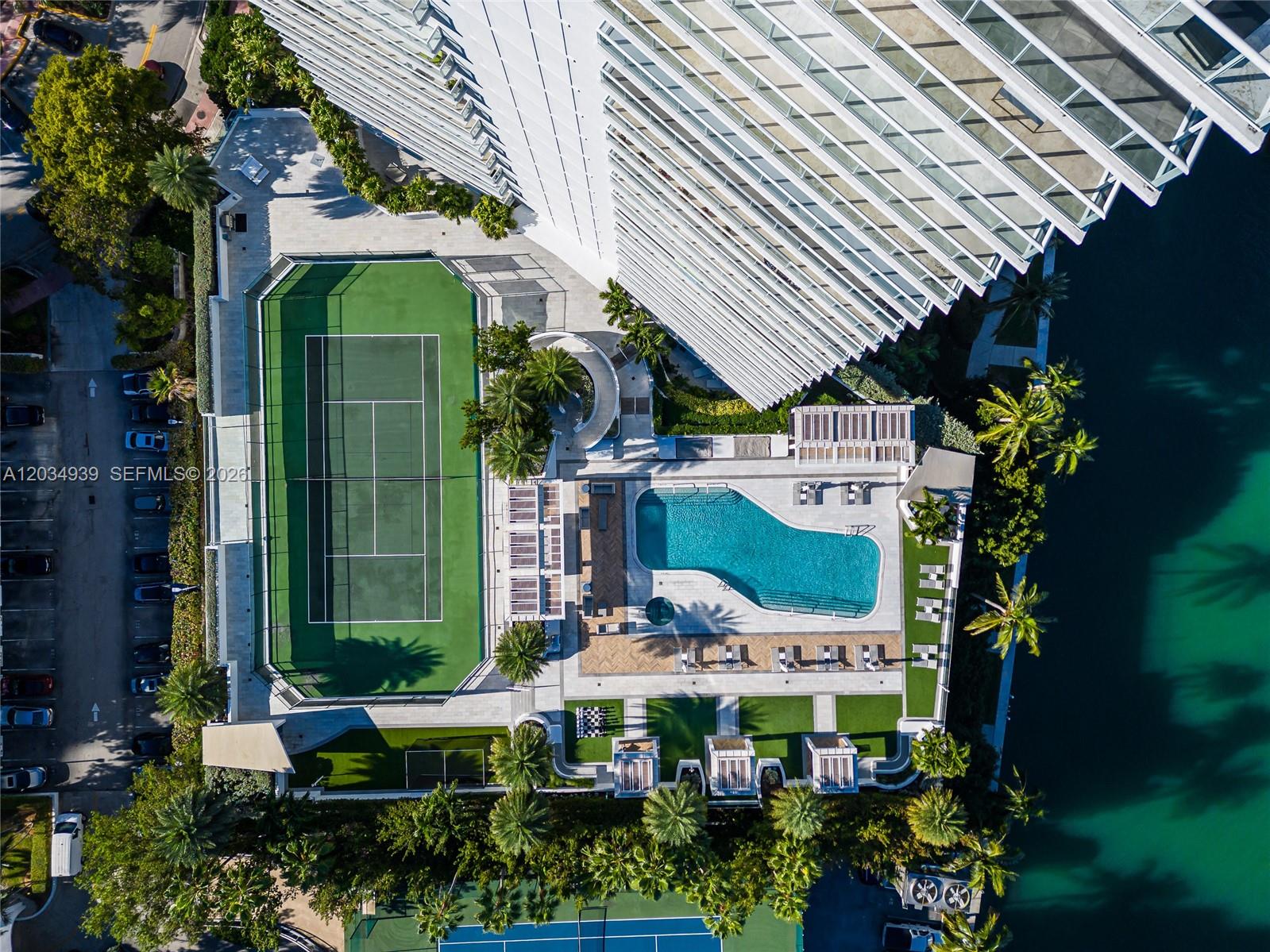 An aerial view shows a high-rise building with a tennis court and swimming pool area — 10 Venetian Way, Miami Beach FL 33139, MIAMI BEACH, FL