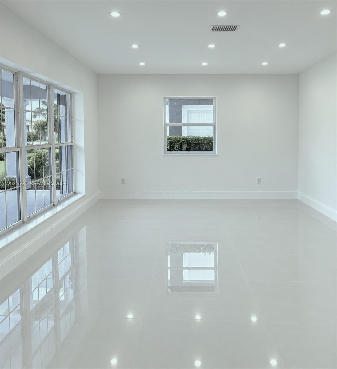 A bright, empty room features white walls, glossy tile flooring, recessed lighting, and large windows — 18935 NW 8th Ave, Miami Gardens FL 33169, MIAMI GARDENS, FL