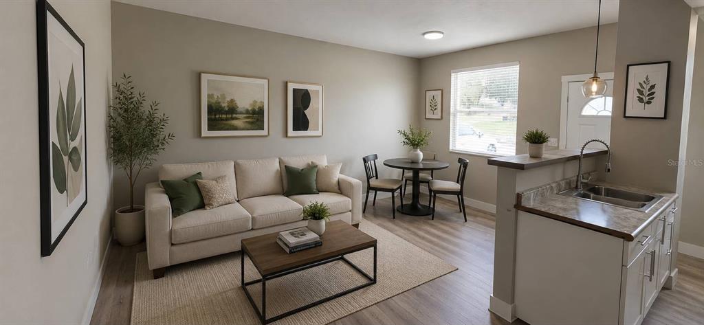This open-concept living area features a sofa, dining table, and kitchen counter with light flooring — 1244 23RD STREET, ORLANDO, FL