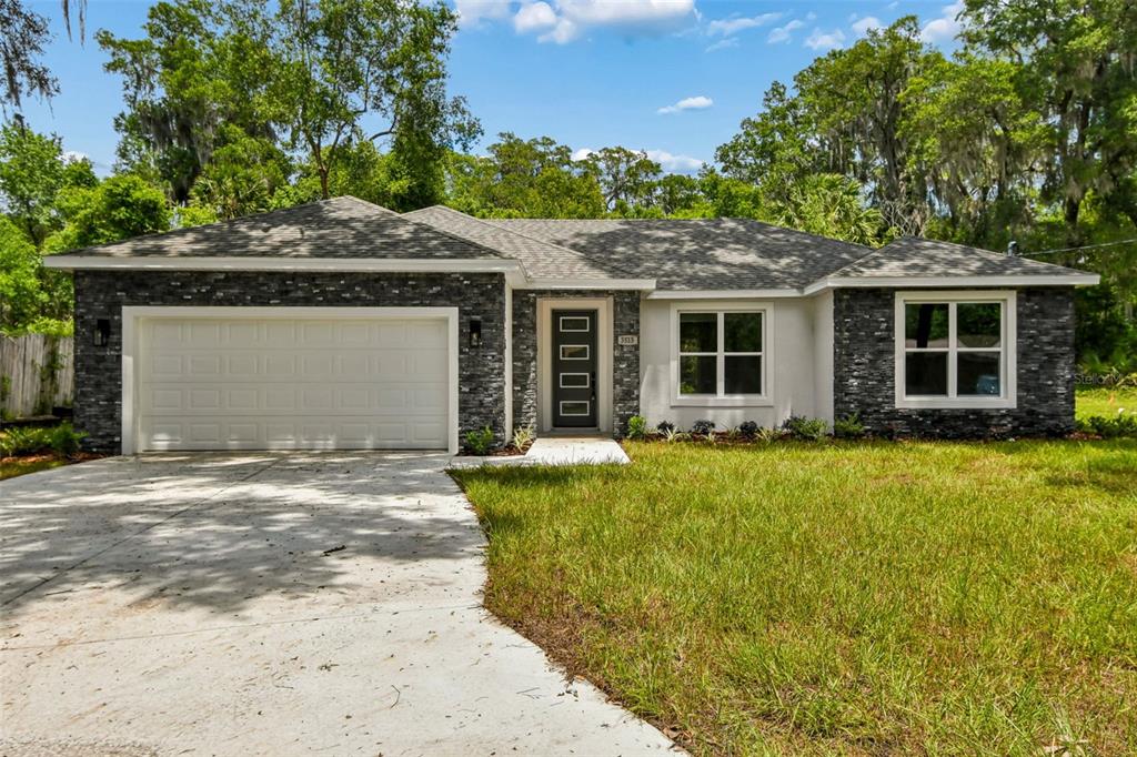 A single-story house with a stone facade, a two-car garage, and a front entrance — 3515 JERATHAN DRIVE, DELAND, FL