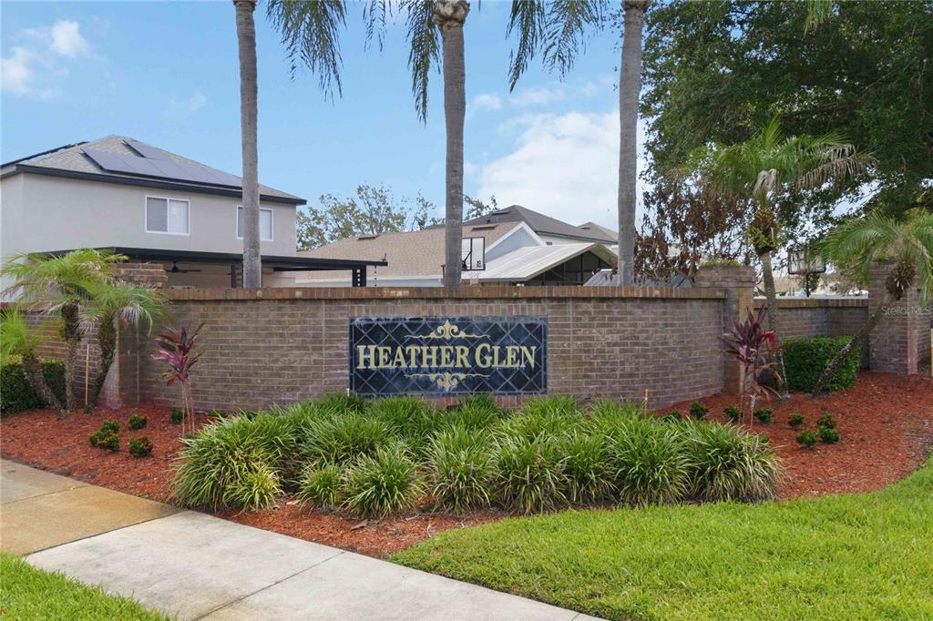 A brick wall with a Heather Glen sign stands in front of a residential neighborhood — 1365 CAREY GLEN CIRCLE, ORLANDO, FL