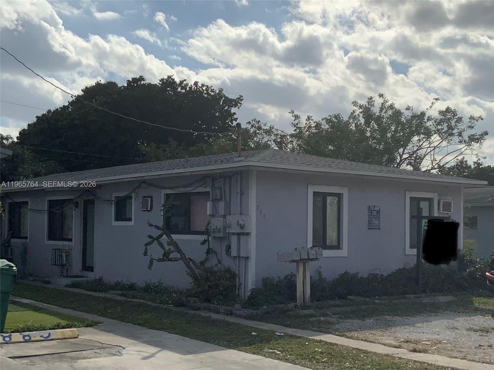 A single-story light-colored house with a flat roof and a cactus in the front yard — 896 NW 103rd St, Miami FL 33150, MIAMI, FL