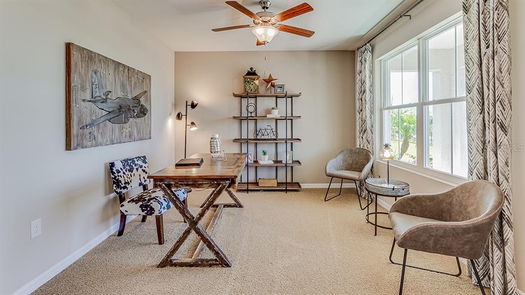 A view through a doorway shows a living area with light wood-look flooring — 10928 RABBIT GROVE TRAIL, PARRISH, FL