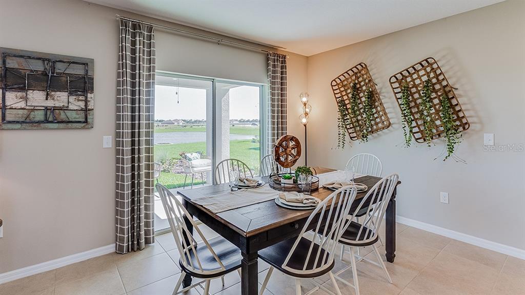 A modern kitchen features white cabinets, stainless steel appliances, and a central island — 10928 RABBIT GROVE TRAIL, PARRISH, FL