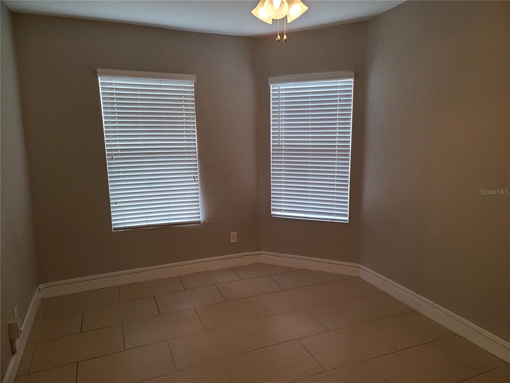 An empty room features beige walls, tile flooring, and two windows with white blinds — 4211 W NORTH A STREET UNIT 5, TAMPA, FL