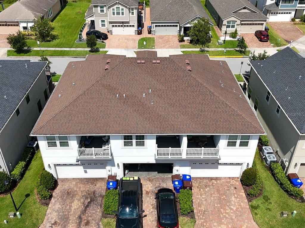 An aerial view of a multi-unit residential building with a brown shingled roof — 2451 VARENNA LOOP, KISSIMMEE, FL