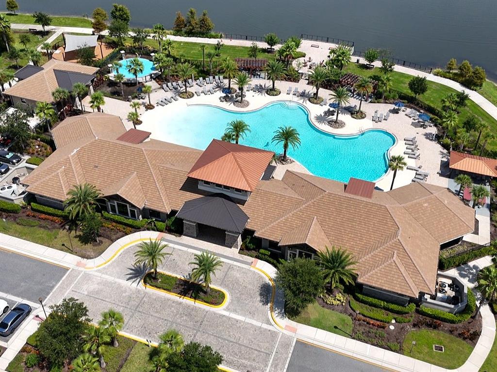 An aerial view of a clubhouse with a large swimming pool and surrounding landscaping — 2451 VARENNA LOOP, KISSIMMEE, FL