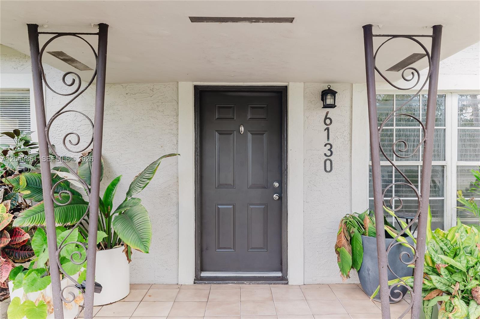 A front entrance features a dark door, house numbers, and decorative metal porch supports — 6130 Flagler St, Hollywood FL 33023, HOLLYWOOD, FL