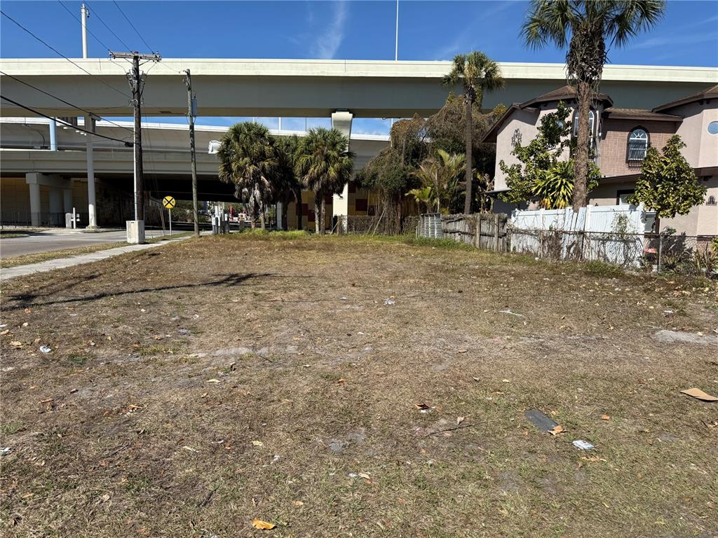 A vacant, grassy lot sits in front of a highway overpass and a residential building — 2602 DURHAM STREET, TAMPA, FL