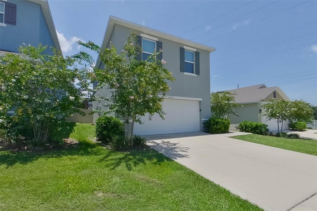 A two-story house with a white garage door and a concrete driveway — 32221 EDSON AVE, LEESBURG, FL