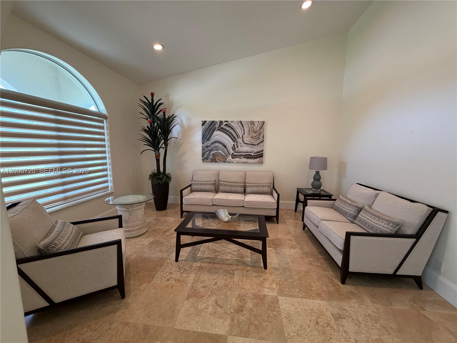 A living room features light-colored furniture, a glass coffee table, and large stone floor tiles — 4810 SW 198th Ter, Southwest Ranches FL 33332, SOUTHWEST RANCHES, FL