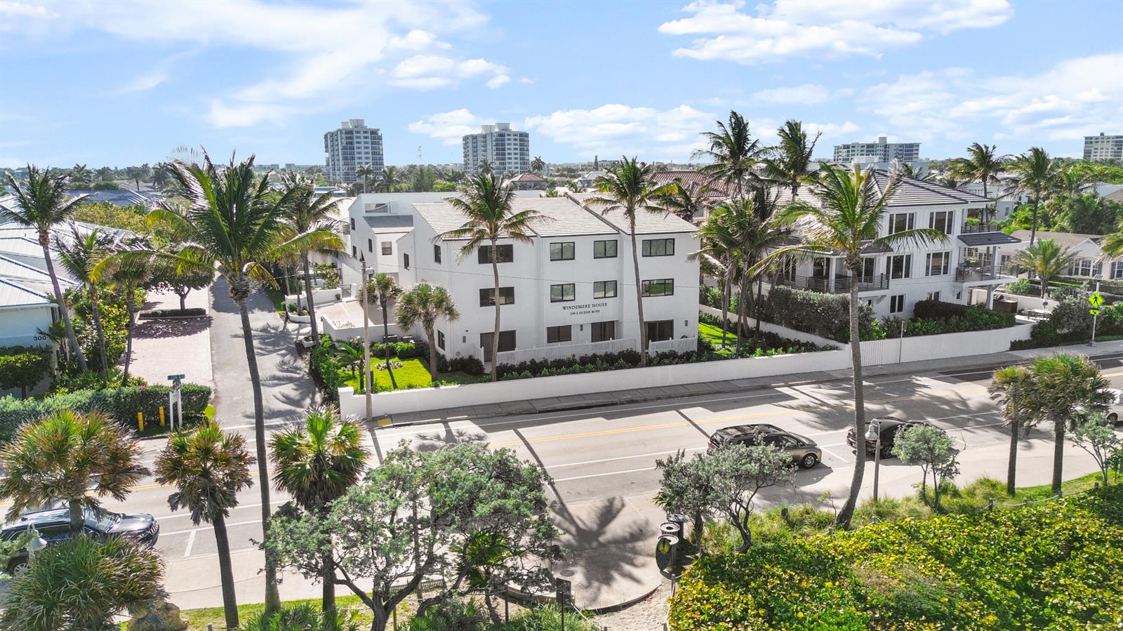 An aerial view shows a white three-story apartment building surrounded by palm trees and roads — 250 S Ocean Boulevard # 254, Delray Beach FL 33483, DELRAY BEACH, FL