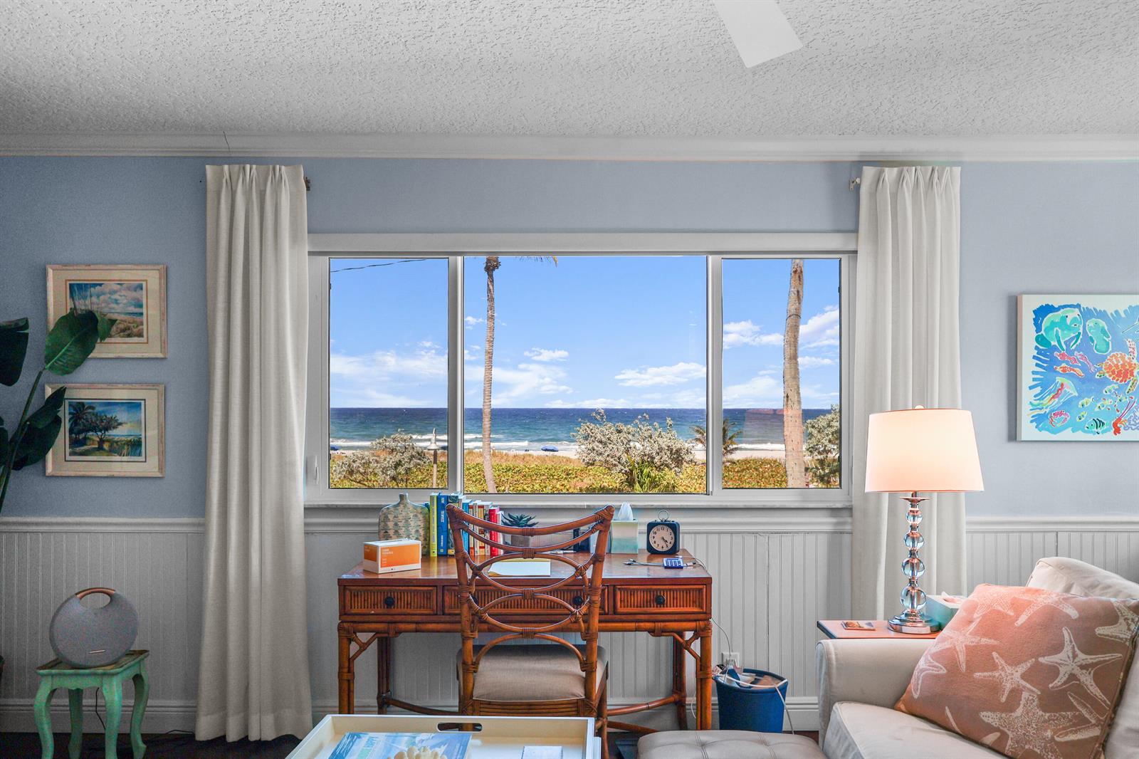 A home office with a rattan desk faces a large window overlooking the ocean — 250 S Ocean Boulevard # 254, Delray Beach FL 33483, DELRAY BEACH, FL