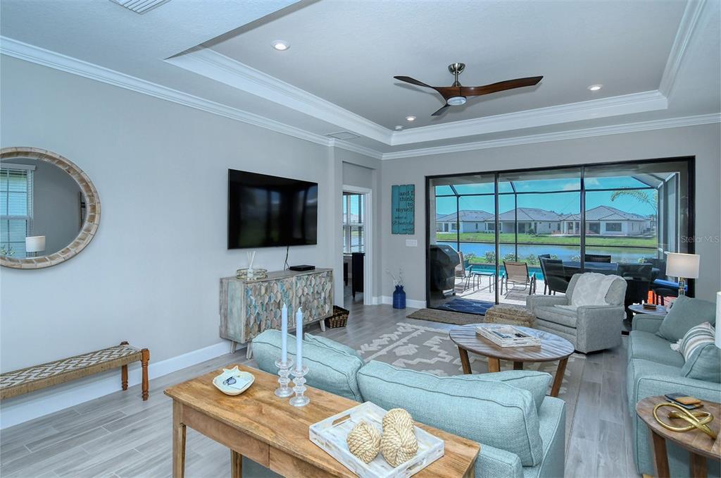 A living room features light blue sofas, a wooden coffee table, and sliding glass doors — 4708 MOTTA COURT, BRADENTON, FL