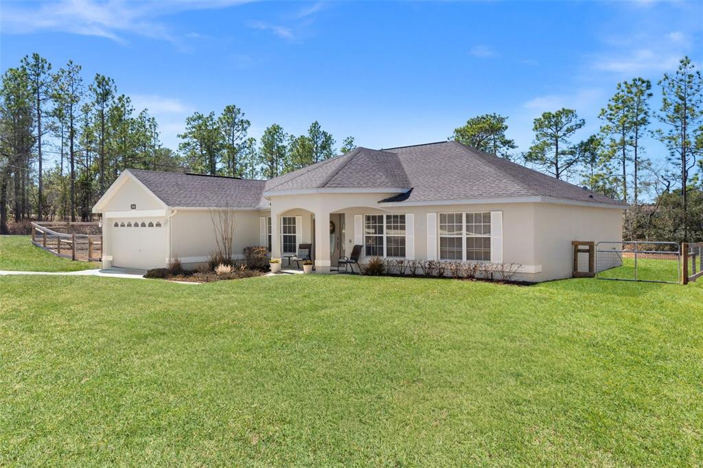 A single-story beige house with a garage and a large front lawn — 15335 FLEETWOOD ROAD, WEEKI WACHEE, FL