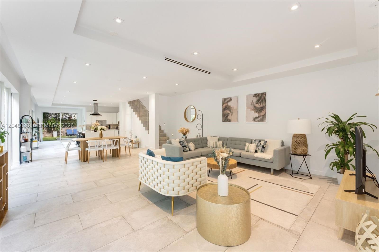 A bright, open-concept living and dining area features light tile floors, modern furniture, and recessed lighting — 2908 Virginia St # 2908, Miami FL 33133, MIAMI, FL