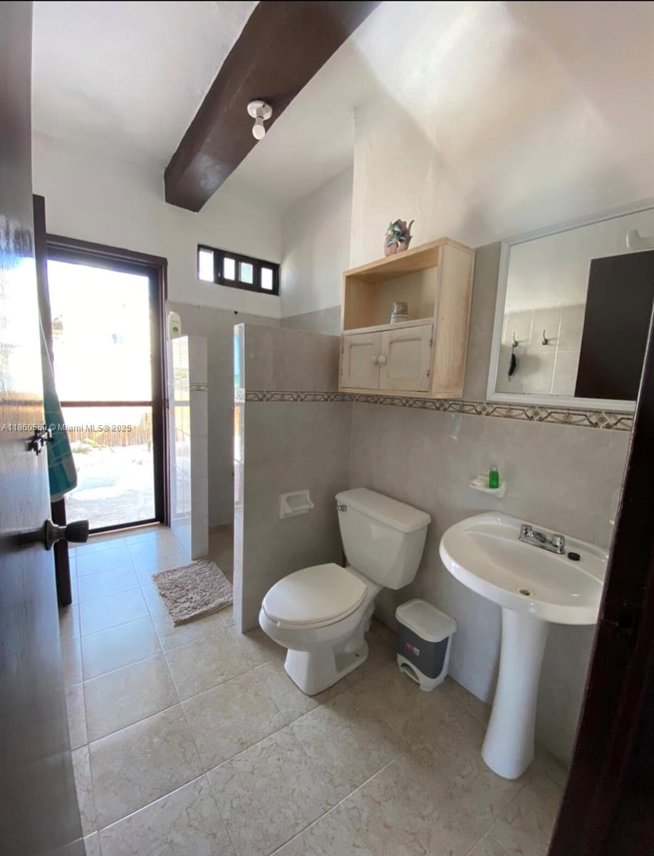 A bathroom features a pedestal sink, a toilet, a wall cabinet, and a glass door — Calle 18 y 2 Telchak Puerto, Mx, Mx