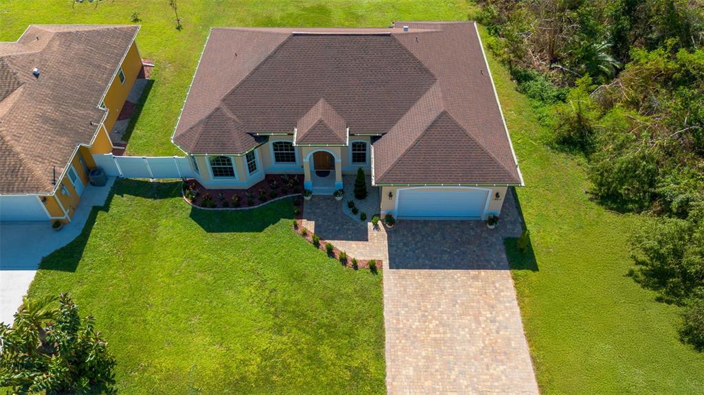 An aerial view of a single-story house with a brown roof and paved driveway — 1900 COLLEEN STREET, SARASOTA, FL