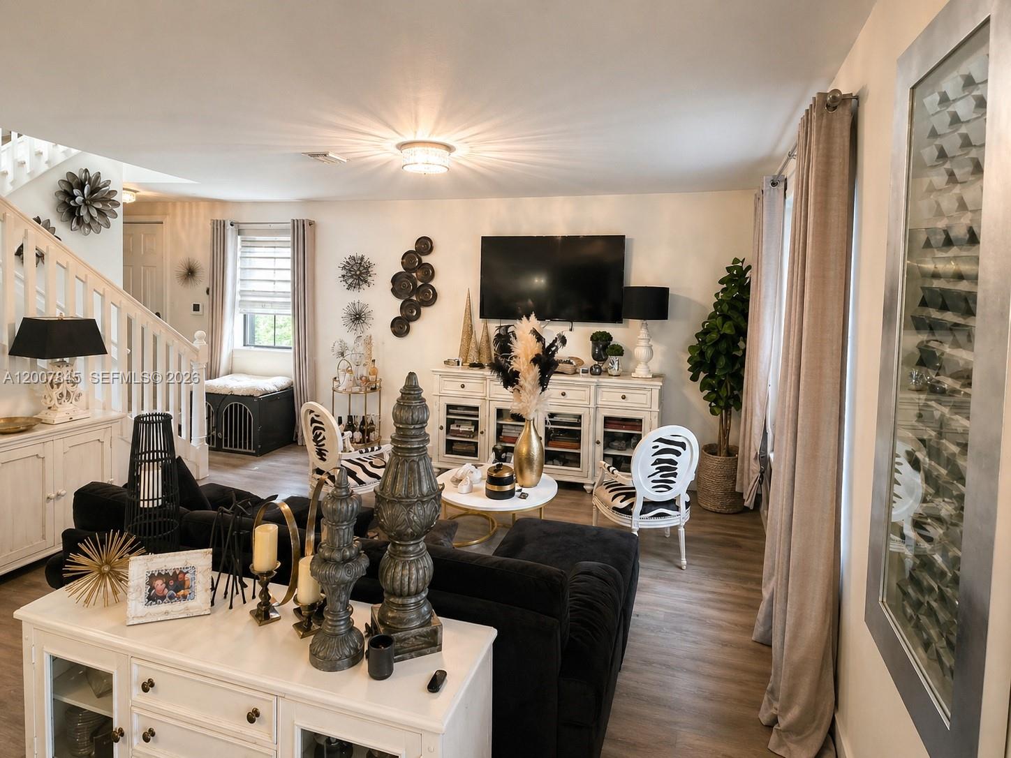 A living room features a black sofa, white cabinetry, zebra-print chairs, and a wall-mounted television — 22405 SW 102nd Ave, Miami FL 33190, MIAMI, FL