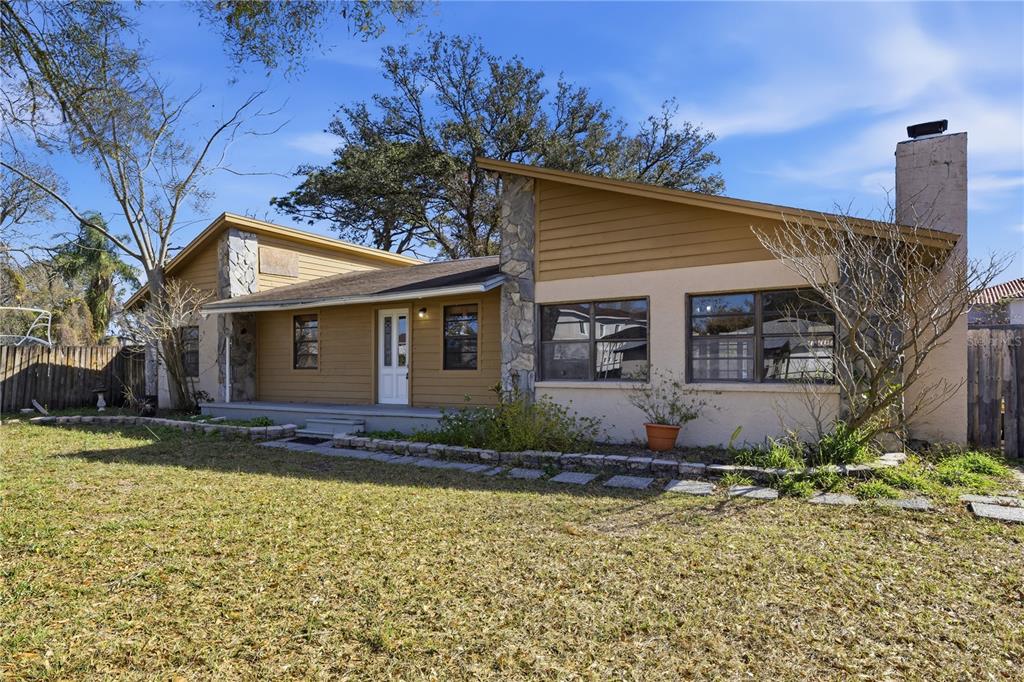 A single-story house with a shed roof, stone accents, and a front porch — 10301 TRAIL RIDGE LANE, TAMPA, FL