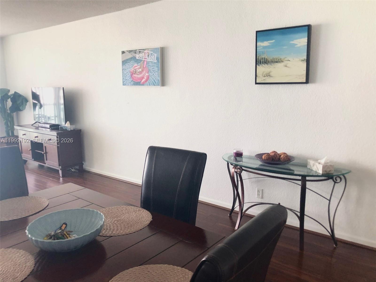 A dining area features a dark wood table, black chairs, and wall art — 3901 S Ocean Dr # 15C, Hollywood FL 33019, HOLLYWOOD, FL