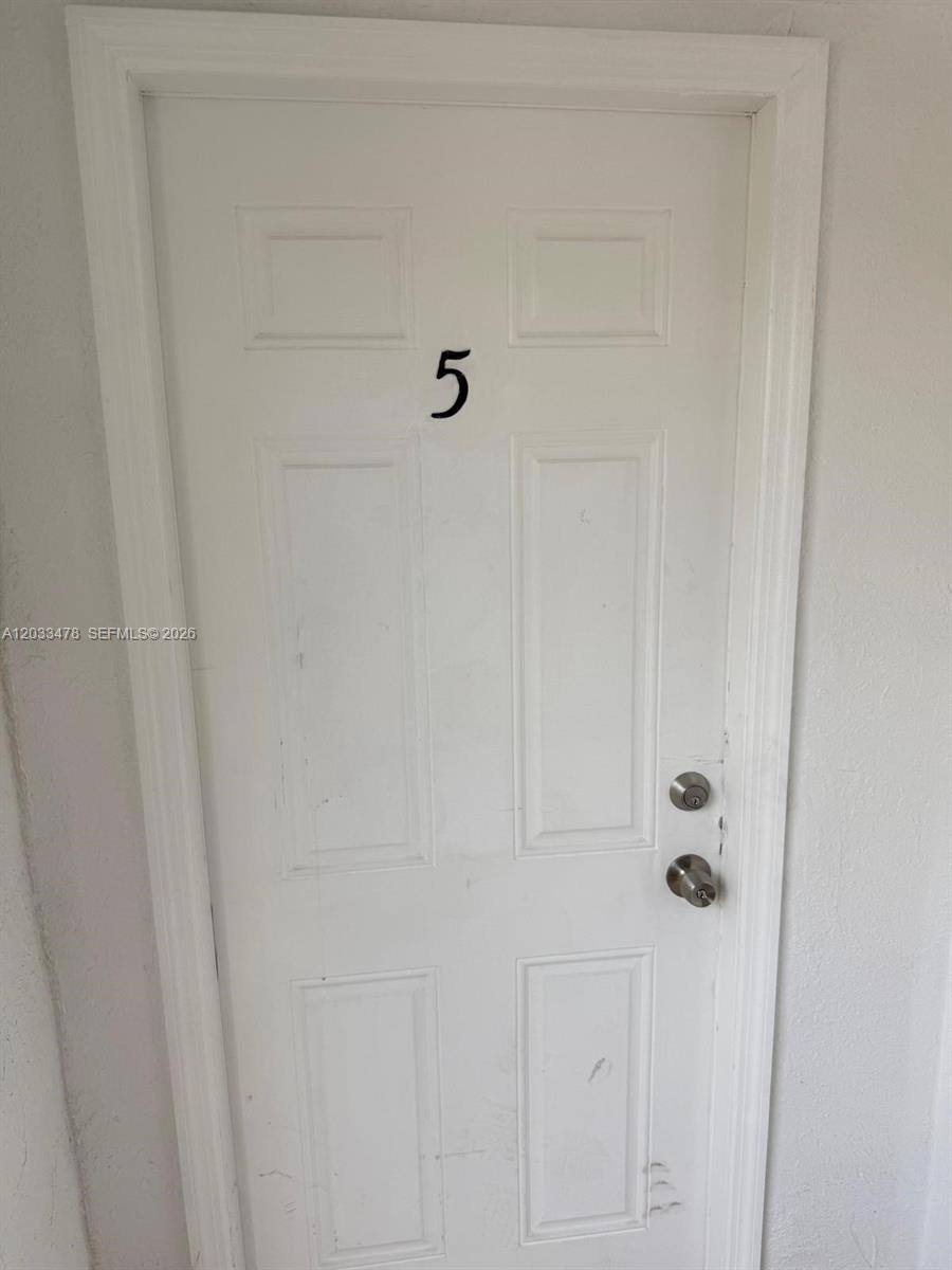 A white, six-panel door marked with the number five features a standard handle and lock — 1612 Harrison St # 5, Hollywood FL 33020, HOLLYWOOD, FL