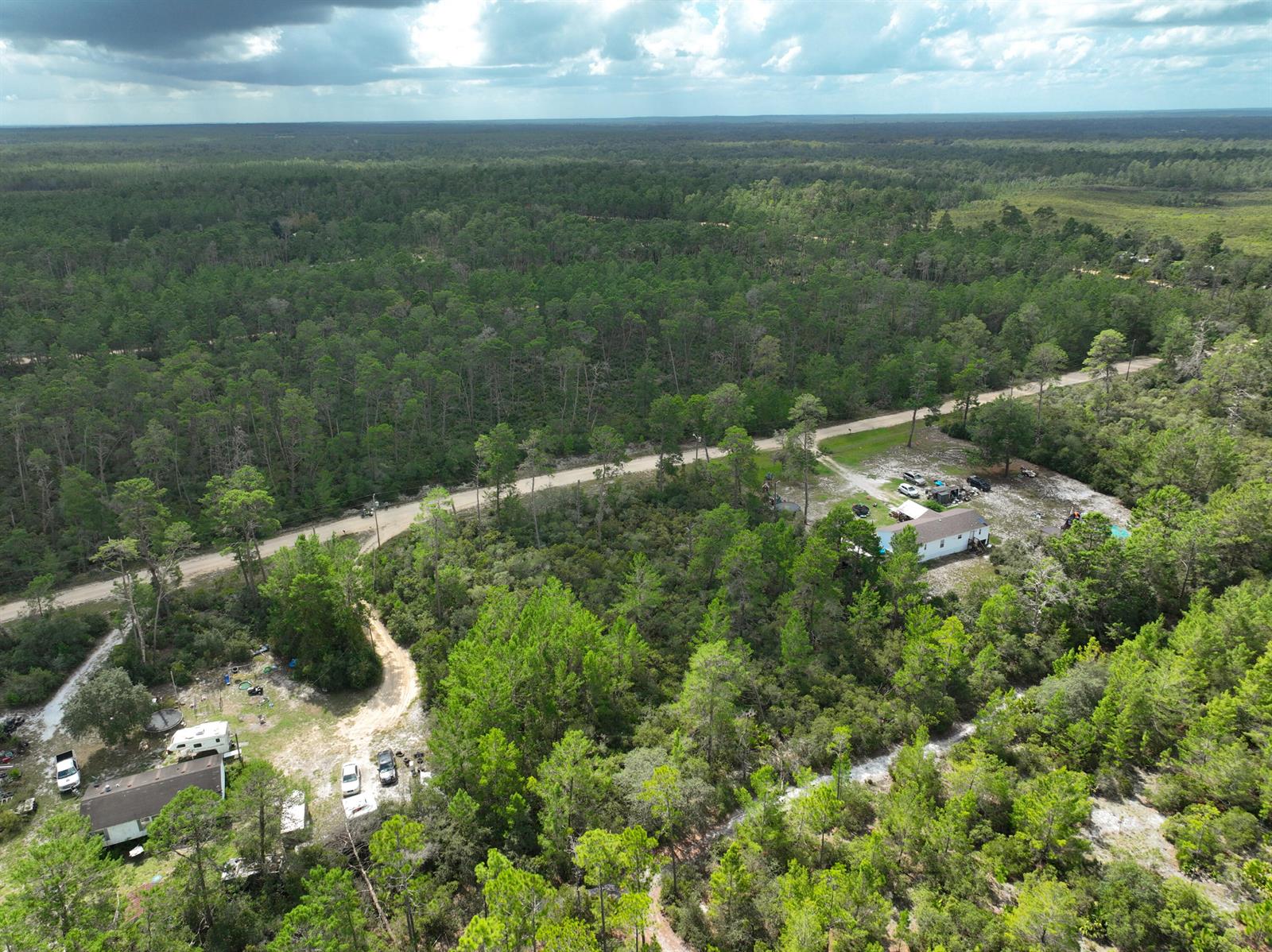 An aerial view shows two houses on large, wooded lots separated by a dirt road — 108 Morningside Drive, FL 32140, FL